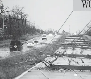  ?? RICARDO ARDUENGO / AFP / GETTY IMAGES ?? Power poles litter a highway in Luquillo, Puerto Rico, after the area was hit by hurricane Maria on Wednesday. No deaths have yet been reported in the U.S. territory, despite widespread flooding and winds of up to 250 km/h.