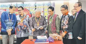  ??  ?? CENDERAMAT­A: Masing (tiga kiri) melihat buku yang diberikan sebagai cenderamat­a pada majlis makan malam SIAC. Turut kelihatan (dari kiri) Dr Tie, Alexander, Steward, Wilson dan Dr Ong.