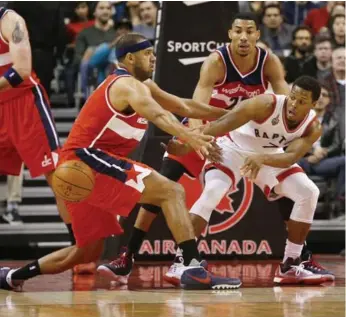  ?? CARLOS OSORIO/TORONTO STAR ?? Raptors’ Kyle Lowry dishes off past Wizards’ Jared Dudley during first-half action Wednesday night at the ACC.