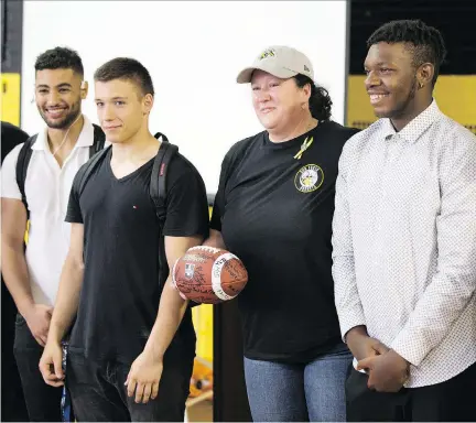  ?? CHRISTINNE MUSCHI ?? Kara La Perralle is presented a football at a memorial for her father, Earl De La Perralle, at Sun Youth headquarte­rs on Saturday.