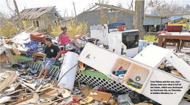  ?? AP ?? Cruz Palma and her son, Jose Duran, look over what is left of her home, which was destroyed by Hurricane Ida, on Thursday, in Golden Meadow, La.