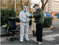  ?? Photo Bloomberg ?? A worker in protective gear checks the health code of a resident at the entrance to a community under lockdown in Beijing.