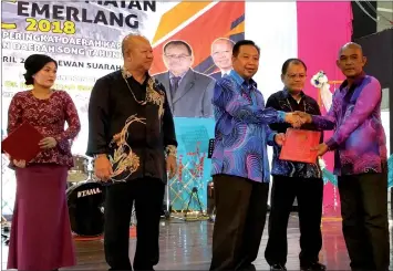  ??  ?? Dr Azhar presents an award to the headmaster of SK Temenggong Koh, Alding Aladdin Michael Ayong. From left are Dangkan and Ringgit.