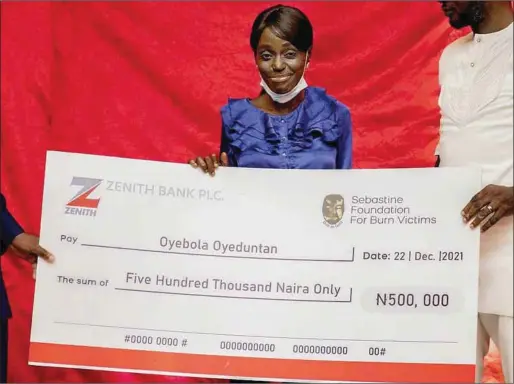  ?? ?? Burn Survivor, Oyebola Oyeduntan being presented a N500,000 educationa­l scholarshi­p by representa­tives of Sebastine Foundation for Burn Victims, at the launch of the foundation recently in Lagos State