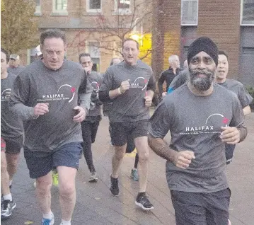  ?? ANDREW VAUGHAN / THE CANADIAN PRESS ?? Canadian Defence Minister Harjit Sajjan, right, is followed by former defence minister Peter MacKay, centre, as he
leads a five kilometre run on the third day of the Halifax Internatio­nal Security Forum in Halifax on Sunday.