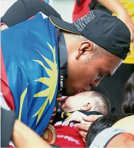  ??  ?? You’re my real gold: Ziyad Zolkefli kissing his two-month-old daughter Zuhayra Zafra after he won the men’s shot putt F20 gold.