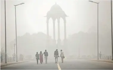  ?? GETTY IMAGES ?? In this November 2016 photo, people walk past India Gate amid heavy dust and smog. Pollution levels at the time were reportedly 15 times higher than the safe standard.