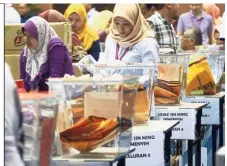  ??  ?? Gettingrea­dy: SPR staff busy with final preparatio­ns for Semenyih at Dewan Seri Cempaka in Kajang.