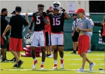  ?? MATIAS J. OCNER / THE MIAMI HERALD ?? University of Miami quarterbac­ks N’Kosi Perry (5) and Jarren Williams (15) confer during the first day of fall training camp in Coral Gables earlier this month. Coach Mark Richt had positive things to say about both after UM’s scrimmage.