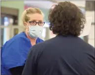  ?? H John Voorhees III / Hearst Connecticu­t Media ?? EMT Eugenia McGovern, from Griffin Health, gathers informatio­n from Anthony Capirichio, of Danbury, who was a walk-in to the COVID-19 vaccine clinic at the Danbury Public Library on Friday.