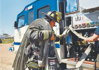  ?? Joe Amon, The Denver Post ?? Firefighte­r Sam Noyes pulls hose for a fire in the burn tower at the Platte Valley Fire Protection District training facility in Kersey.