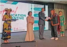  ?? ?? Phang (third left) presents an education incentive to John Vianney who successful­ly completed the Namlifa Fellow Certified Life Practition­er (FCLP) module, as Saseedaran (second right, partly seen) and others look on.