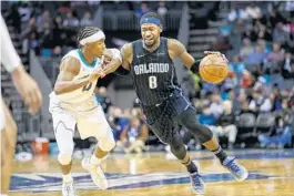  ?? NELL REDMOND/AP ?? Orlando Magic guard Terrence Ross, right, drives around Charlotte Hornets guard Devonte' Graham in the second half.