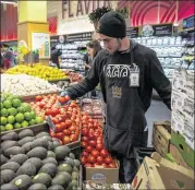  ?? DAVID PAUL MORRIS / BLOOMBERG ?? A Whole Foods Market employee in Oakland, Calif., arranges produce last month. The Austin-based grocer said it spent three years on coming up with its Responsibl­y Grown rating system.