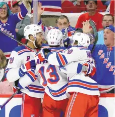  ?? CHRIS SEWARD / ASSOCIATED PRESS ?? New York Rangers left wing Alexis Lafrenière (13) celebrates his goal against the Carolina Hurricanes with teammates K’Andre Miller (79) and Artemi Panarin (10) during the Rangers’ 3-2 overtime win on Thursday in Raleigh, N.C.