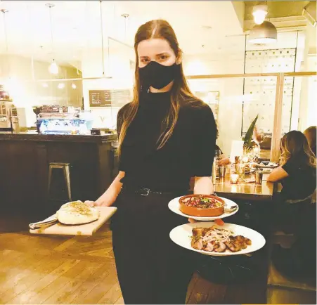  ?? MIA STAINSBY ?? Lili Watson serves up some dishes at Medina After Dark, which pairs wine and sharing dishes.