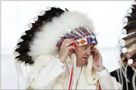  ?? NATHAN DENETTE — THE CANADIAN PRESS VIA AP ?? Pope Francis adjusts a traditiona­l headdress he was given after his apology to Indigenous people for the church’s role in residentia­l schools during a ceremony July 25in Maskwacis, Alberta, as part of his papal visit across Canada.