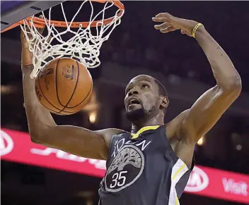  ?? — AP ?? Golden State Warriors' Kevin Durant scores against the Miami Heat during the second half of an NBA game on Sunday.