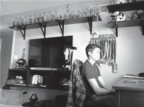  ?? STACEY WESCOTT/CHICAGO TRIBUNE ?? Ryan Mohler, 15, a freshman at Neuqua Valley High School, sits in his room and watches an instructio­nal video on CPR for his online physical education class.