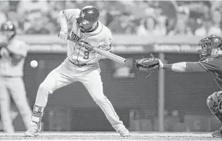  ?? Joe Robbins / Getty Images ?? Marwin Gonzalez lays down a squeeze bunt to drive in the go-ahead run for the Astros in the eighth inning Friday night at Cleveland. His bunt drove in Jose Altuve from third base.