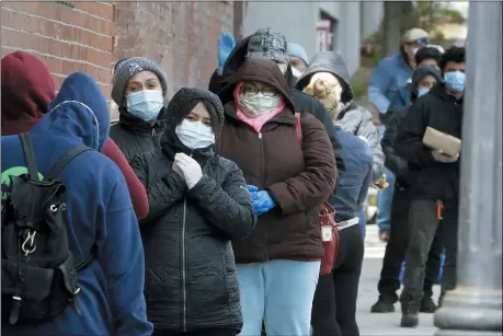  ?? THE ASSOCIATED PRESS ?? People wear protective masks out of concern for the coronaviru­s while standing in line outside a pop-up food pantry on April 16in Chelsea, Mass.