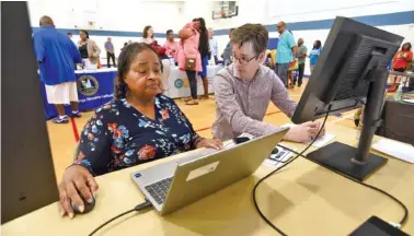  ?? STAFF PHOTO BY MATT HAMILTON ?? On Monday, Tim Moreland, right, with the City of Chattanoog­a, talks to Lena Ellis as she beta tests an affordable housing search tool during an affordable housing fair at the Glenwood Community Center.