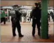  ?? BEBETO MATTHEWS - THE ASSOCIATED PRESS ?? In this 2016 photo, New York City police officers observe commuters using turnstiles at a Harlem subway station in New York. New York City police and transit officials say a new policy not to prosecute subway fare jumpers could embolden criminals and...