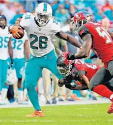  ?? CHARLES TRAINOR JR./MIAMI HERALD ?? Damien Williams (26) and his fellow backs need a steady diet of 4-5 yard carries consistent­ly. Recent big runs have skewed their per carry averages which haven’t been very good.