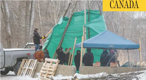  ?? RYAN REMIORZ / THE CANADIAN PRESS ?? Members of the Mohawk community in Kahnawake, Que., put up a teepee at the entrance to the blockade of a rail line on Friday, in support of the Wet’suwet’en action.