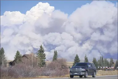  ?? DAVID ZALUBOWSKI — THE ASSOCIATED PRESS ?? Smoke rises from mountain ridges as a motorist heads eastbound on Highway 34while a wildfire burns Oct. 22near Granby, Colo.