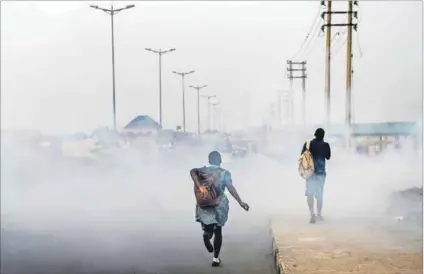  ??  ?? Dangerous: A smoky Port Harcourt street. Doctors have warned of the health-related consequenc­es of the city’s poisonous black soot. Photo: Pius Utomi Ekpei/AFP