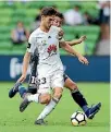  ??  ?? Phoenix midfielder Matthew Ridenton looks to escape the challenge of Victory counterpar­t Matias Sanchez during Sunday’s 2-1 defeat.