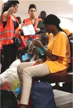  ??  ?? A female migrant with a child sits waiting in the immigratio­n hall at Roissy-Charles de Gaulle airport.