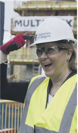  ??  ?? If the hat fits: Nicola Sturgeon wears it well on a visit to the site of Glasgow University’s new learning and teaching hub yesterday. She said the GERS figures show ‘Scotland is on the right trajectory’.