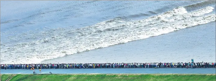  ?? TANG HUASEN / FOR CHINA DAILY ?? Thousands of people gather on the bank of the Qiantang River last year to get a view of the annual tidal bore in Hangzhou, Zhejiang province.