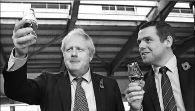  ??  ?? Britain’s Prime Minister Boris Johnson, (L), with Douglas Ross, the minister for Scotland, who resigned on May 26 over the controvers­y involving the PM’s aide breaking lockdown rules. (Foto: KHON2)