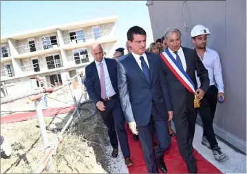  ?? (Photo AFP) ?? Le Premier ministre Manuel Valls, accompagné du maire de Gignac-La-Nerthe, Christian Amiraty, a visité hier un chantier de logement social.