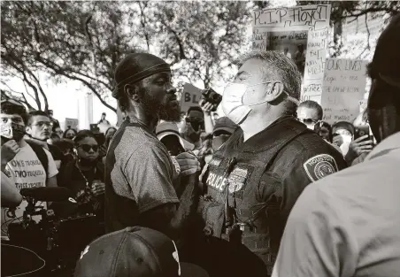  ?? Elizabeth Conley / Staff photograph­er ?? A protester and a Houston officer come together following a march and rally with Floyd’s family on June 2.