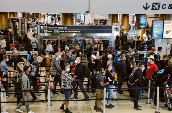  ?? Lea Suzuki/The Chronicle ?? People wind their way in a line created by stanchions at a security checkpoint on Jun 15, 2022, at San Francisco Internatio­nal Airport. It is recommende­d to wear an N95 mask in crowded, poorly ventilated places, especially when there’s no need to talk.