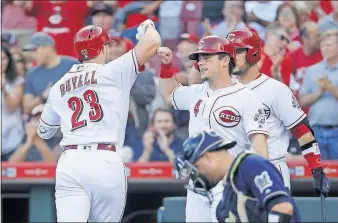  ?? [JOHN MINCHILLO/THE ASSOCIATED PRESS] ?? The Reds’ Adam Duvall, left, celebrates with Scooter Gennett after hitting a two-run home run off Brewers starter Junior Guerra during the first inning.
