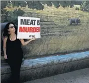 ?? Jay L. Clendenin Los Angeles Times ?? WOMAN PROTESTS the slaughter of pigs at the Farmer John meatpackin­g facility in Vernon in 2013.