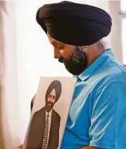  ?? Ross D. Franklin / AP ?? Rana Singh Sodhi, de 49 años, muestra una foto de su hermano asesinado, Balbir Singh Sodhi, en Arizona.