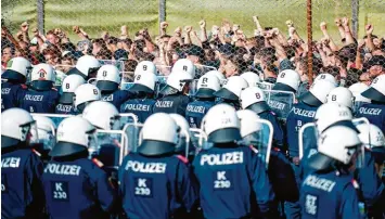  ?? Foto: Rene Gomolj, afp ?? Polizeisch­üler simulieren einen Flüchtling­sansturm vor ihren Kollegen auf der anderen Seite.