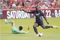  ??  ?? SANDY: Manchester United forward Romelu Lukaku, right, scores against Real Salt Lake goalkeeper Lalo Fernandez during the first half of a friendly soccer match Monday, in Sandy, Utah. — AP