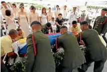  ?? PHOTO: REUTERS ?? Former Philippine First Lady Imelda Marcos, seated at right, and her children look on near the flag-draped coffin of former Philippine dictator Ferdinand Marcos during burial rites at the heroes’ cemetery in Manila.