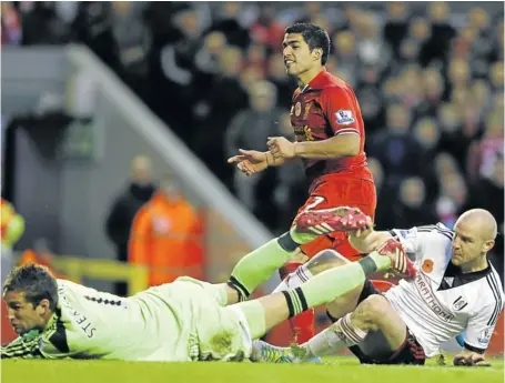  ?? Picture: REUTERS ?? ANFIELD HERO: Liverpool’s Luis Suarez, centre, scores one of his two goals against Fulham goalkeeper Maarten Stekelenbu­rg during the English Premier League soccer match in Liverpool yesterday