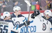  ?? MARTTI KAINULAINE­N — LEHTIKUVA VIA AP ?? The Winnipeg Jets’ Patrik Laine, center, celebrates in Helsinki, Finland after scoring his second goal Thursday.