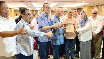  ??  ?? One of the viraled pictures which shows Hajiji (fourth from left), Masidi (third from left), Azizah (second from right) and others posing with what seems to be a PPBM membership form.