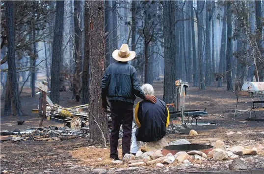  ??  ?? Gilbert Torres comforts his wife, Ursula, after 2007’s Ojo Peak fire ripped through their property in the Cibola National Forest