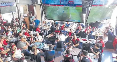  ?? A. GUERRERO ?? Rojinegros. Hinchas de Newell’s en el bar Paso, de Pellegrini y Paraguay. La fiesta fue “canalla”.